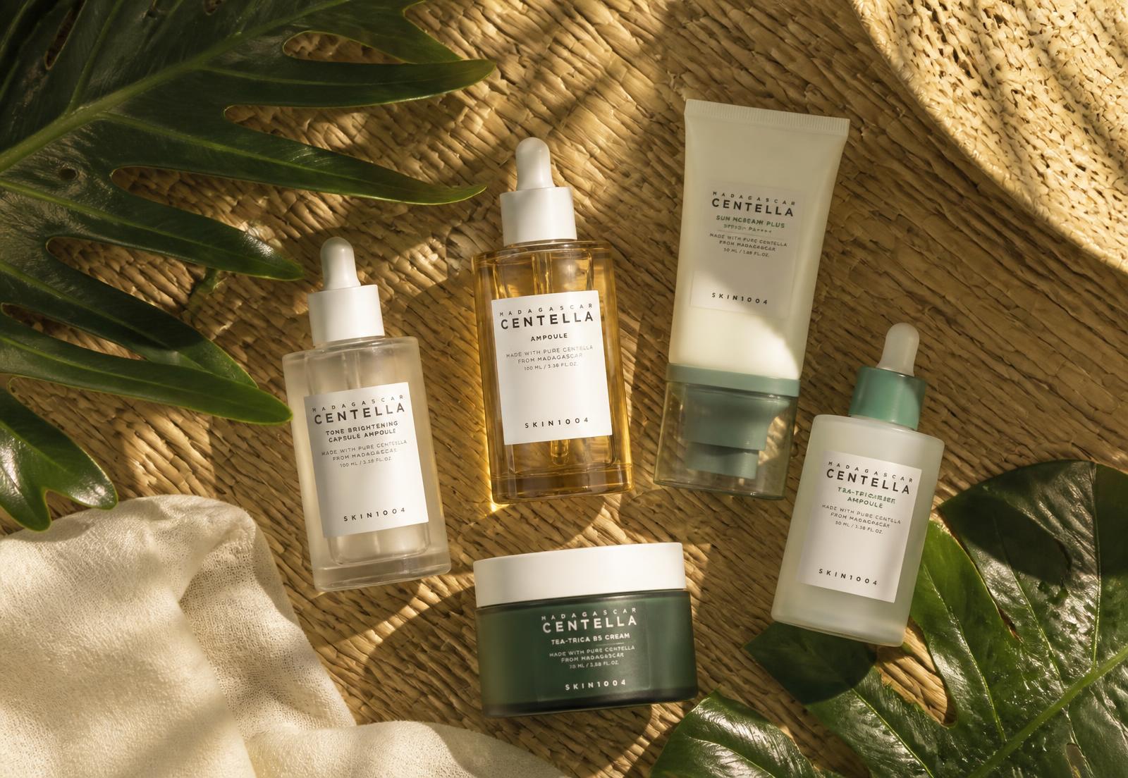 Korean skincare bottles arranged on a woven mat with tropical leaves in warm light